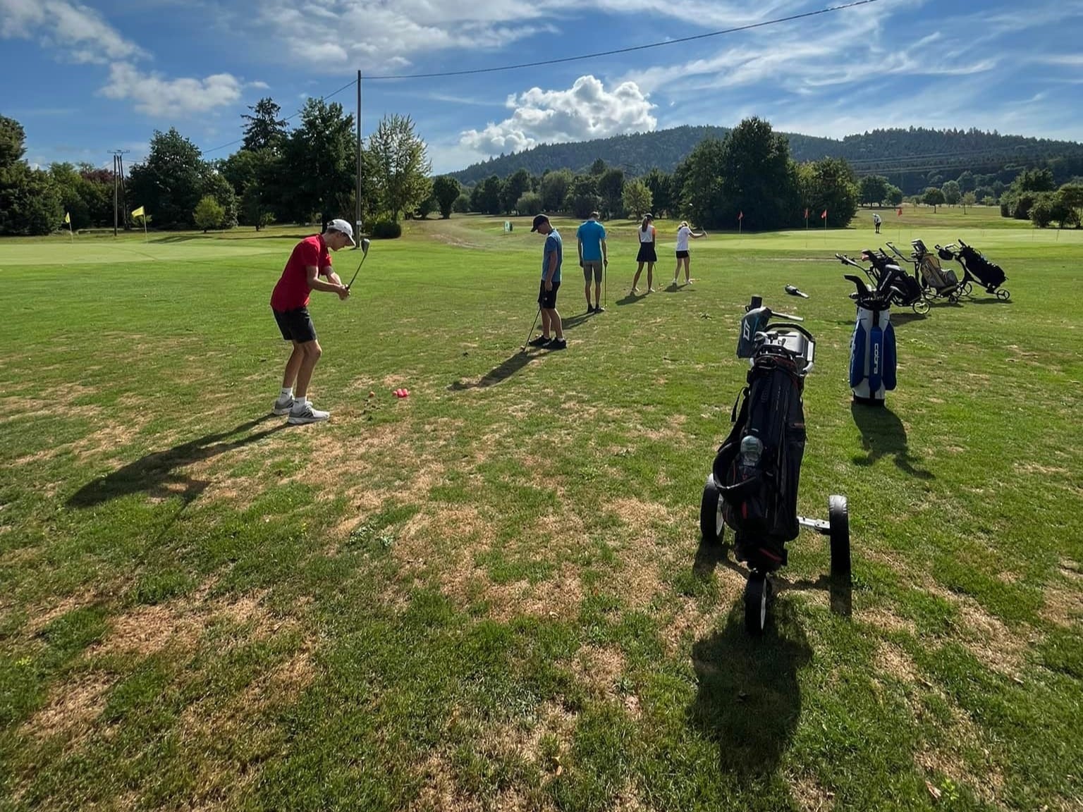 eine gruppe an menschen spielen golf auf einem golfplatz