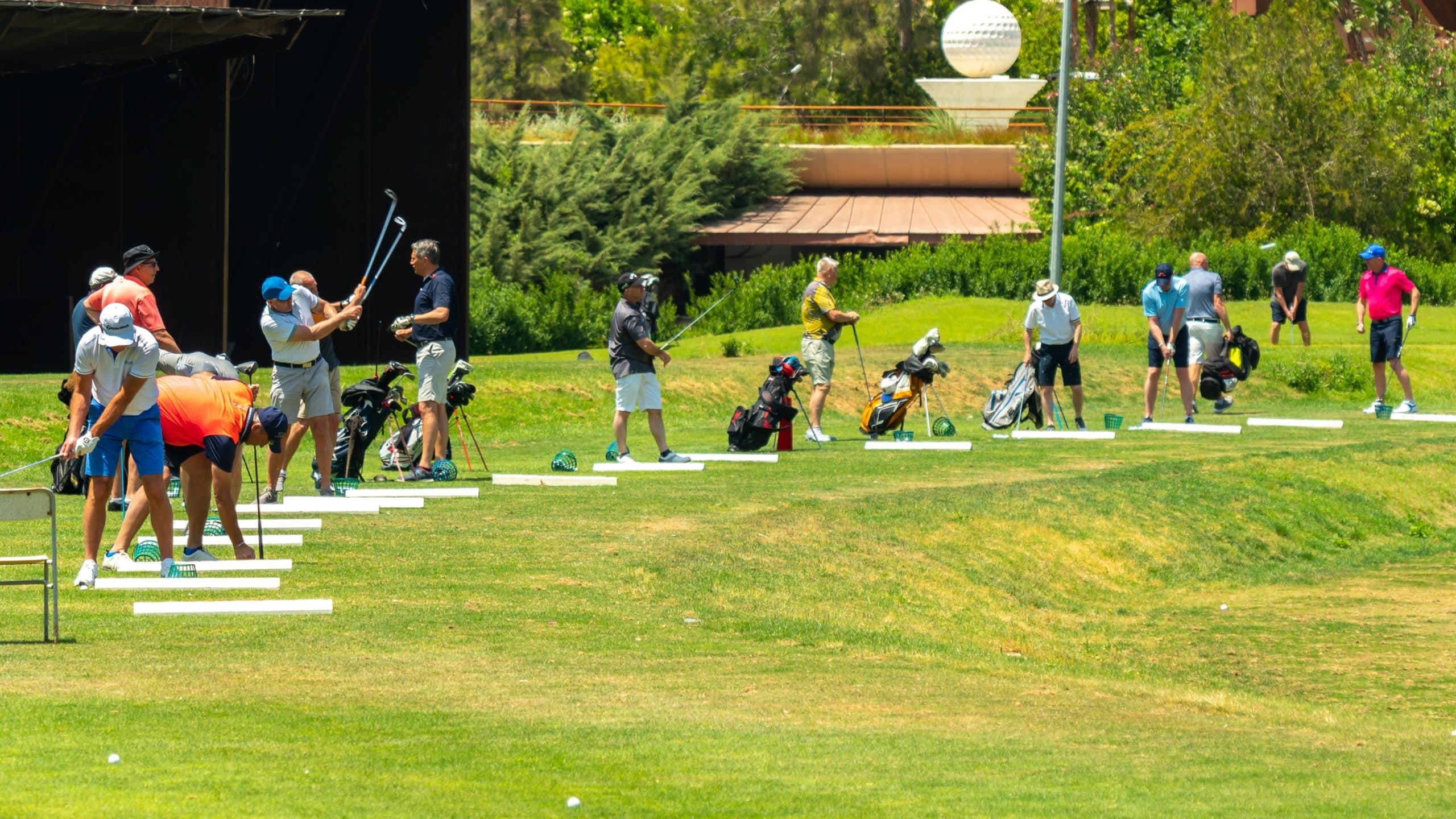 eine gruppe an menschen spielt golf auf einem golfplatz