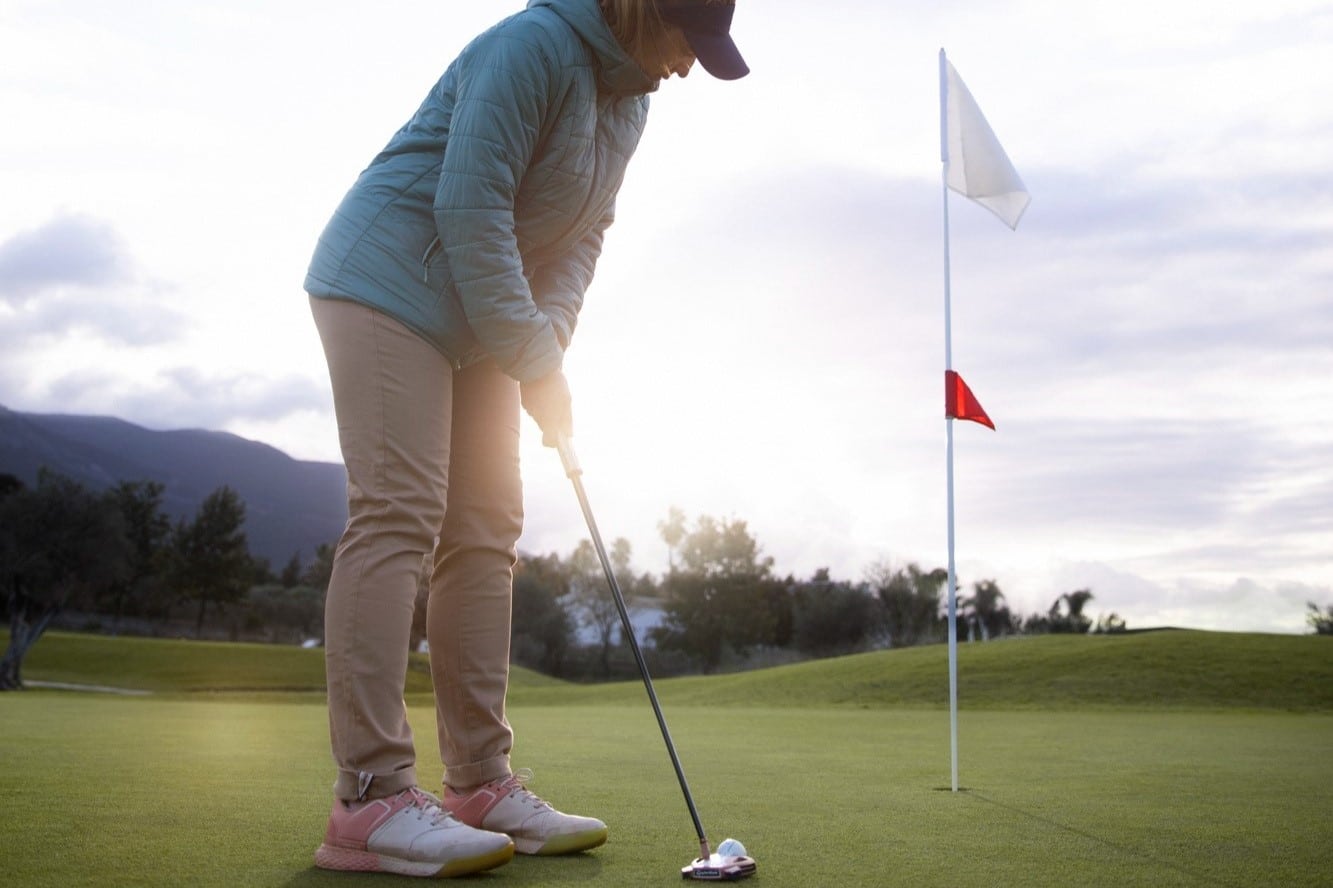 eine frau die draußen golf spielt